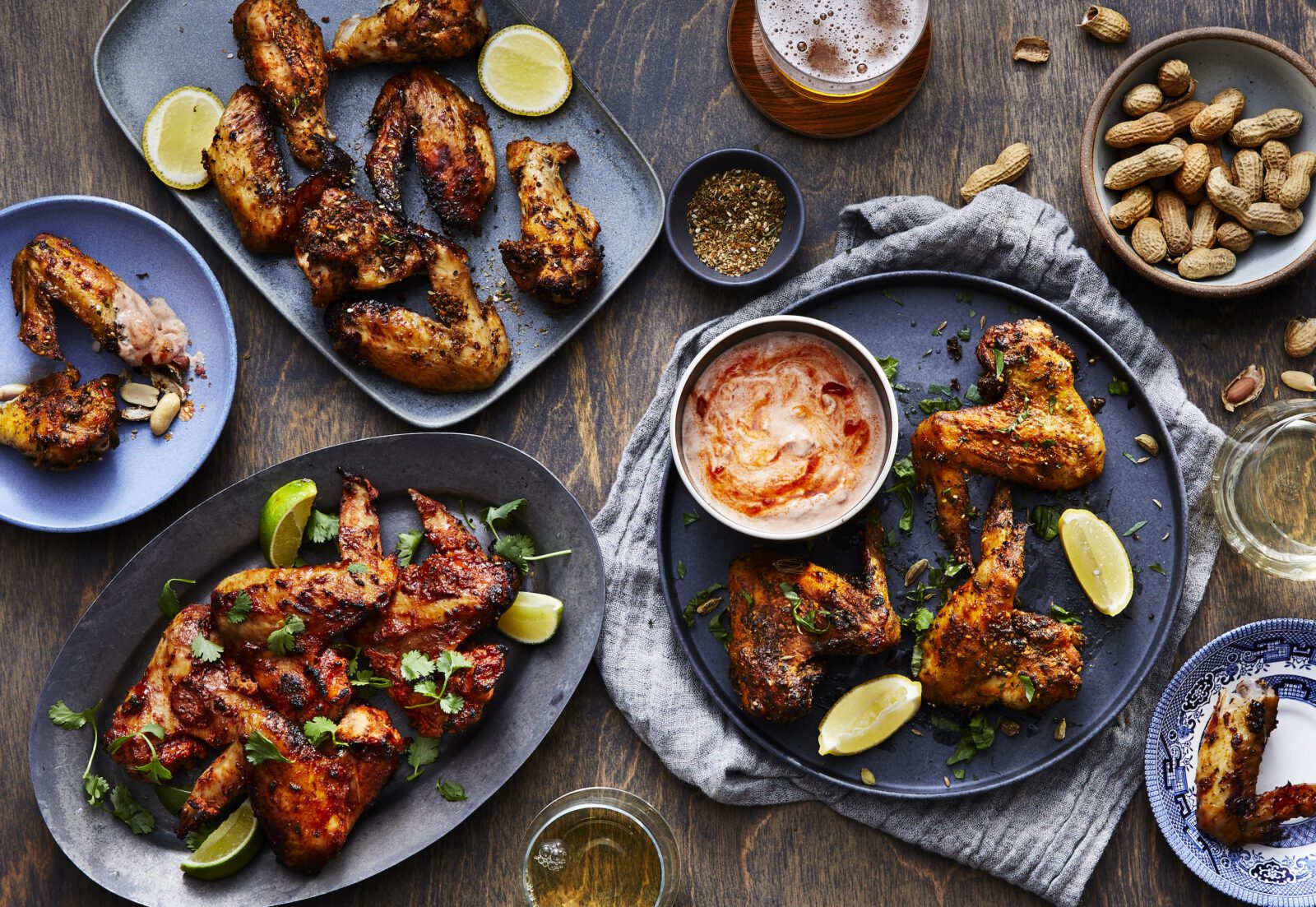 Assorted plates of tandoori chicken wings served with lime wedges, dip, and peanuts