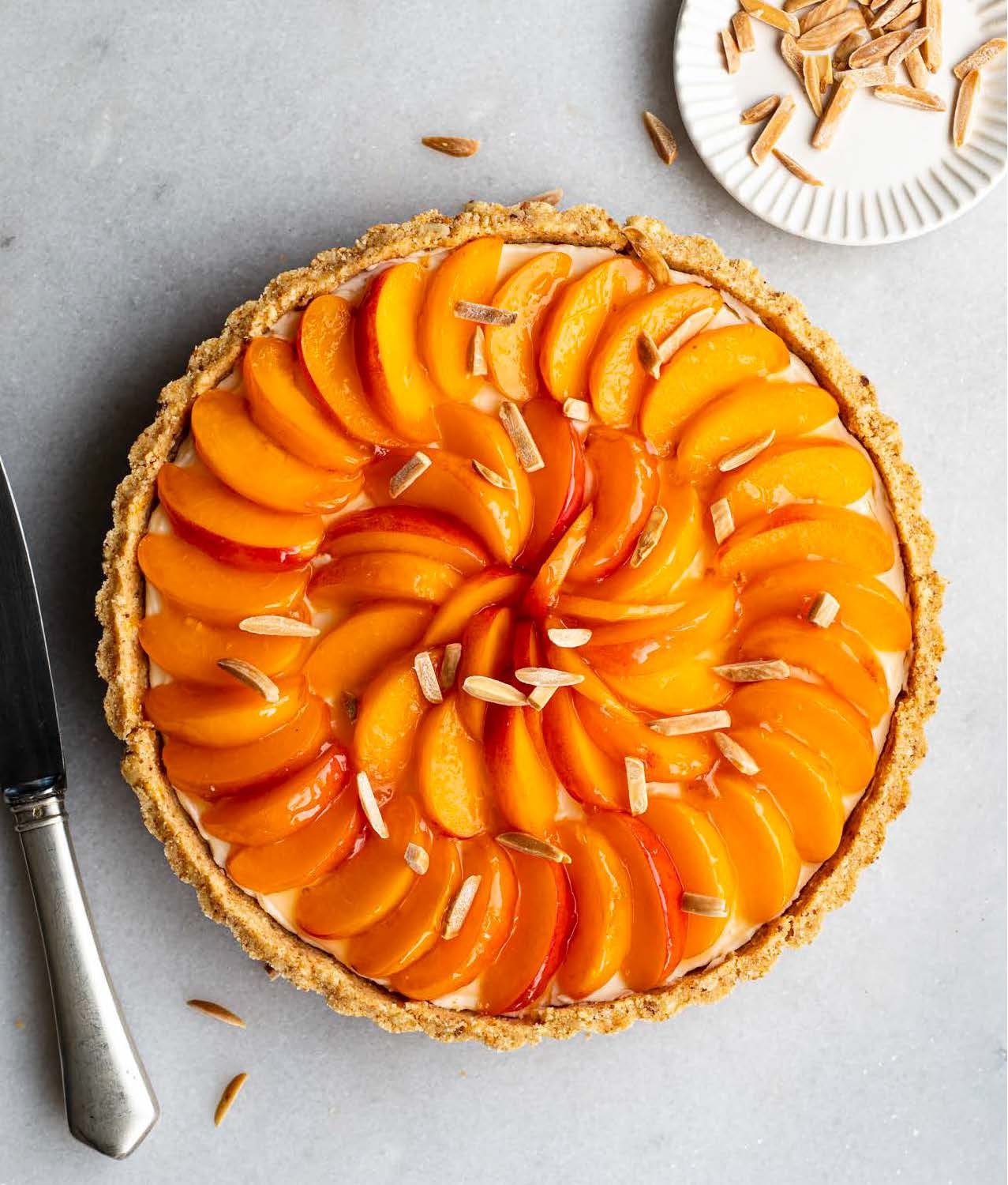 Apricot mascarpone crostata with glossy apricot slices arranged in a spiral over creamy filling