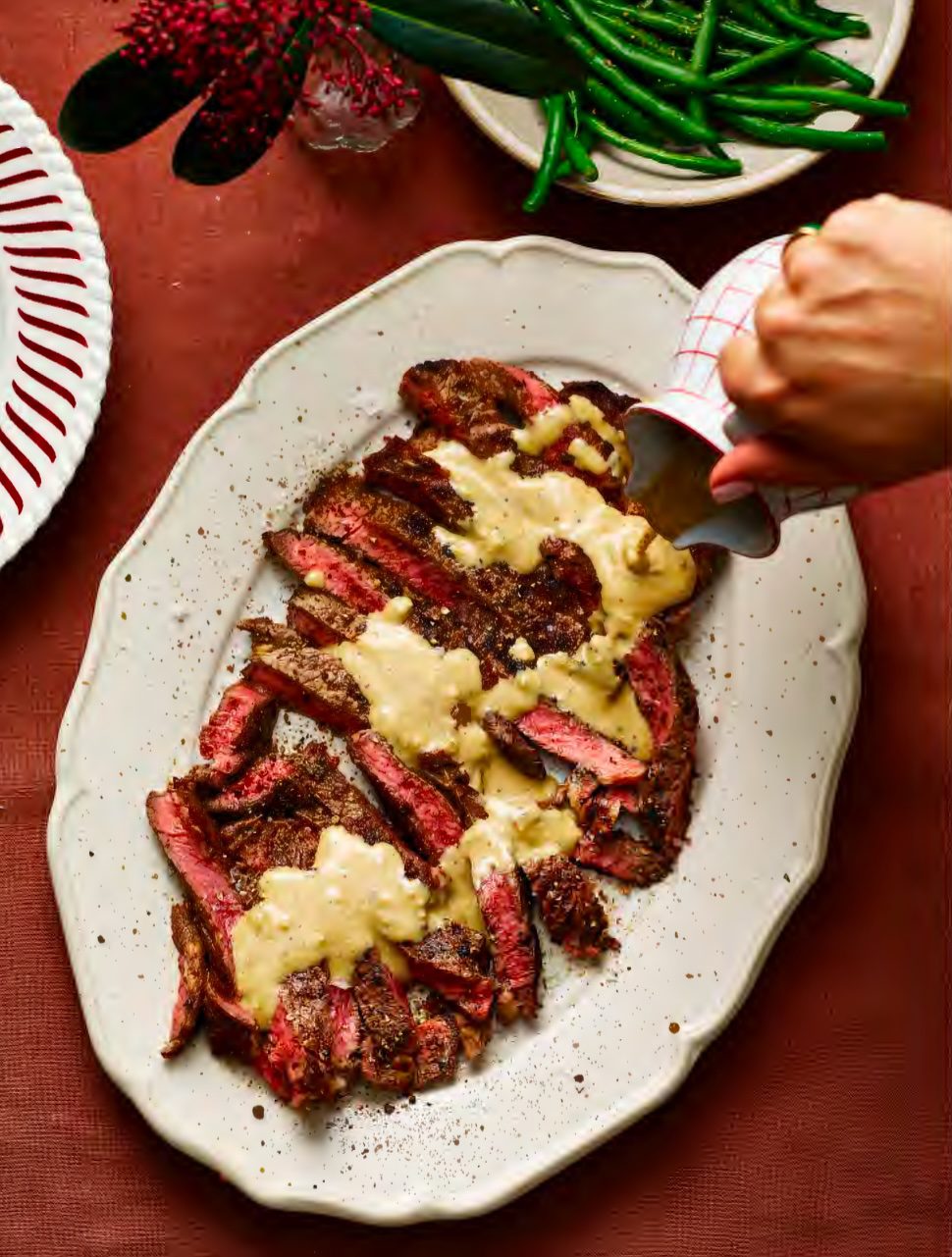 Peppered rib‑eye steak on a plate, topped with creamy whisky peppercorn sauce.